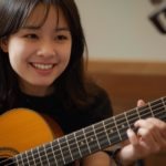 クラシックギターレッスンをする笑顔の日本人女性